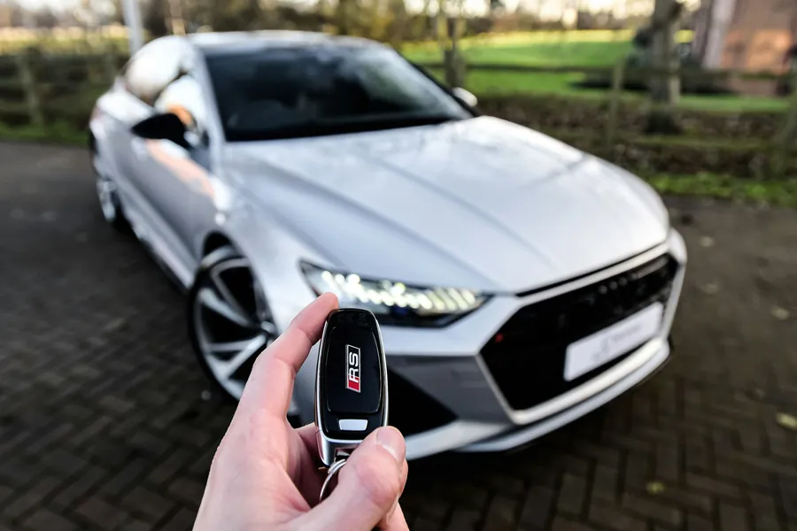 Holding the key fob in front of a silver car